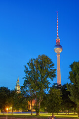 Fototapeta premium The famous Television Tower with the tower of the Marienkirche in Berlin at night