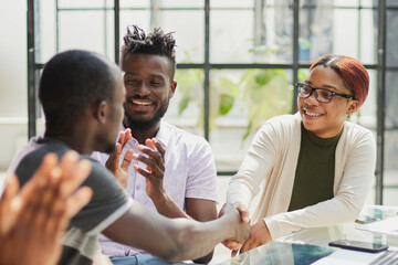 Smiling african american man shaking hands with a business partner at a meeting, greeting, getting to know