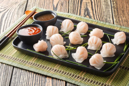 Har gow is a traditional Cantonese dumpling stuffed with shrimp closeup on the plate on the table. Horizontal