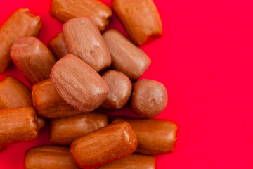 Pile of Freeze Dried Chocolate Candy Rolls Isolated on a Red Background