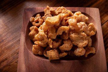 Chicharrones. Deep fried pork rinds, crispy pork skin pieces, traditional mexican ingredient or snack served with lemon juice and red hot chili sauce.