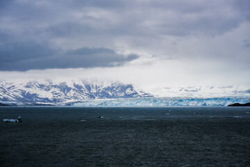 Cruise to Hubbard Glacier Bay in Alaska with floating ice bergs and drift ice floes on ocean water surface surrounded by snow cap mountains and wildlife wild nature scenery Last Frontier adventure