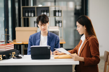 Asian business team and lawyers discussing contract papers sitting at the table. Concepts of law,...