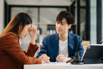 Business people compassionately holding hands and discussing contract papers with laptop and...