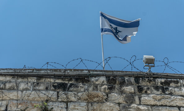 bandera de israel en barda con alambre de puas
