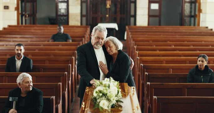 Funeral, church and couple hug by coffin for goodbye, mourning and grief in memorial service. Depression, sad family and man embrace woman by casket in chapel for greeting, loss and burial for death