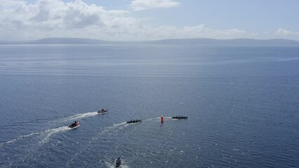 Aerial high angle view looking down over currach boats racing around buoy towards county clare, ireland