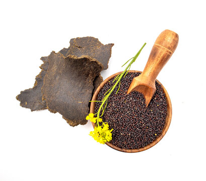Mustard seeds, flower and mustard cake on white background