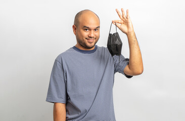 Handsome young man smiling and happy with protection mask. Charming male standing with on isolated white background. Asian people pose  with white backdrop.