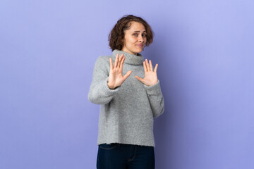 Young English woman isolated on purple background nervous stretching hands to the front