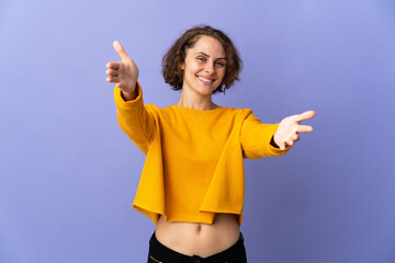 Young English woman isolated on purple background presenting and inviting to come with hand - obrazy, fototapety, plakaty