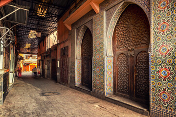 Beautiful Moroccan building with mosaic and wooden doors facing on an alley inside the Marrakesh or Marrakech Medina. 