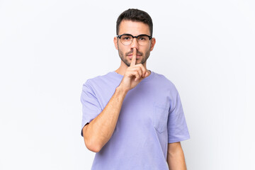 Young caucasian man isolated on white background showing a sign of silence gesture putting finger in mouth