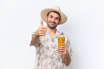 Young caucasian man holding a cocktail isolated on white background with thumbs up because something good has happened