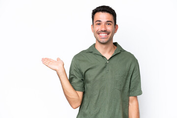 Fototapeta premium Young handsome man over isolated white background holding copyspace imaginary on the palm to insert an ad