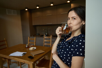 Beautiful woman in a cute dress is drinking tea