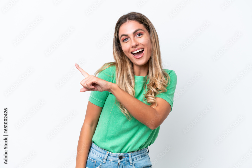 Wall mural Young Uruguayan woman isolated on white background surprised and pointing side