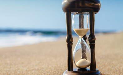 hourglass on the beach vintage-inspired image of an hourglass on the beach, with sepia tones and...