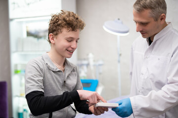 A man doctor talks to his boy patient and advises him on medicine