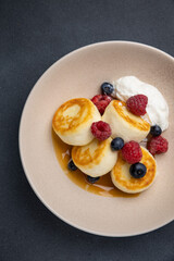 Delicious breakfast. cheesecakes with raspberries and blueberries. Close-up