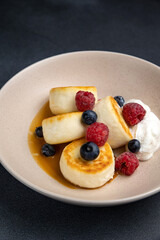 Delicious breakfast. cheesecakes with raspberries and blueberries. Close-up