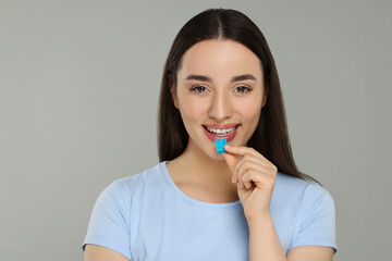 Happy young woman with bubble gum on color background