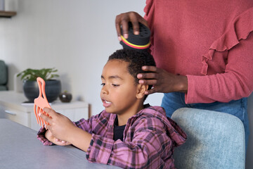 Unrecognizable african mother styling her son hair using an afro curl wave or twists sponge.
