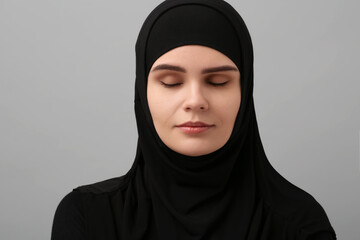 Portrait of Muslim woman in hijab on light gray background