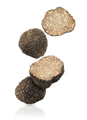 Cut and whole truffles falling on white background