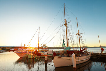 An old sailing ship in a port with a beautiful sunrise on the horizon in Hobart, Tasmania