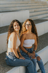 Dos chicas jóvenes juntas sonriendo y disfrutando dandose abrazados y mostrando cariño. Hermanas...