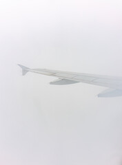 View from the airplane window at a beautiful cloudy sky and the airplane wing