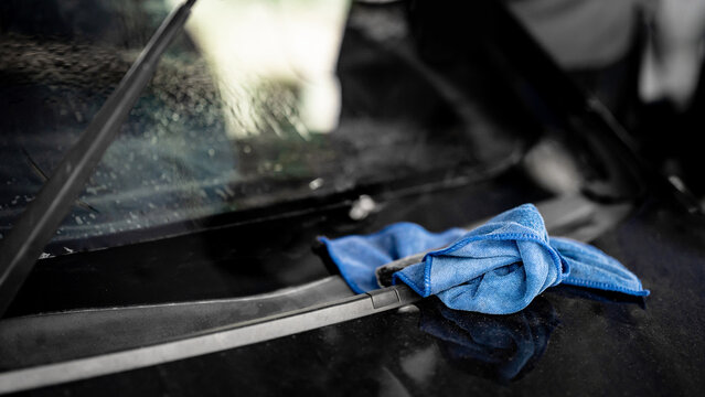 Blue cloth wipe or rag on front windscreen. Cleaning tool for car wash and car film tint installation