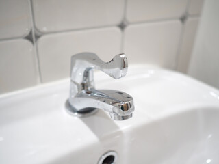 Bathroom interior with sink and faucet. Closeup photo, blurred.
