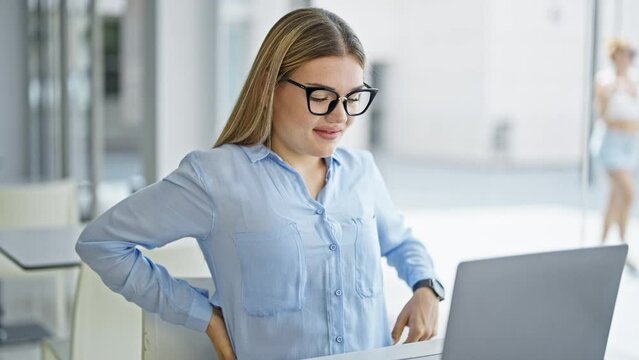 Young blonde woman business worker using laptop suffering for backache at office