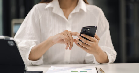 Businesswoman using mobile phone to chat with friends during free time.