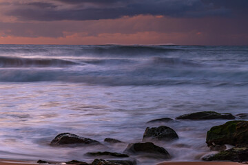 Obraz premium Sunrise seascape with low clouds and waves