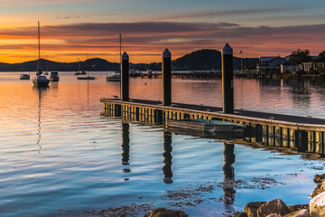 Beautiful sunrise with high cloud and boats on the water