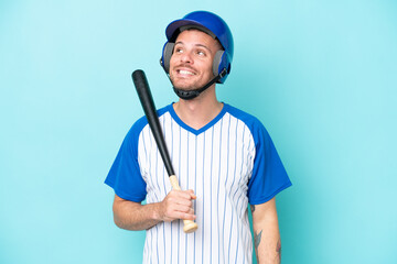 Baseball player with helmet and bat isolated on blue background thinking an idea while looking up