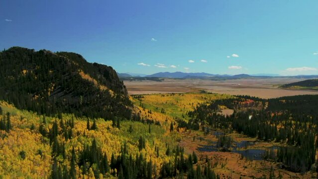 Fall colors in Colorado cinematic aerial drone Aspen trees yellow gold orange green turning of seasons autumn bluebird sunny afternoon stunning peaceful mountain lake Jefferson FairPlay up movement