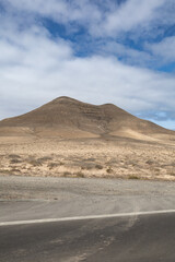 Fototapeta na wymiar View of the strange, unfriendly but fascinating deserted landscape of the island volcanoes of the center of Fuerteventura. North part of the island.