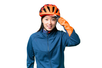 Young cyclist woman over isolated chroma key background looking far away with hand to look something - obrazy, fototapety, plakaty