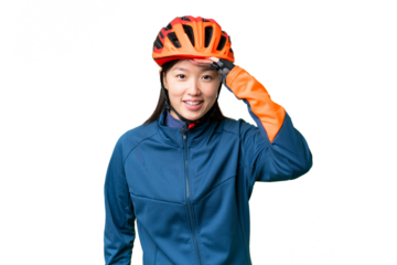 Young cyclist woman over isolated chroma key background looking far away with hand to look something