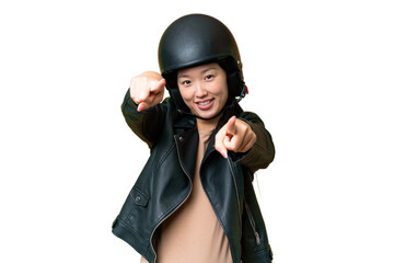 Young Asian woman with a motorcycle helmet over isolated chroma key background points finger at you while smiling