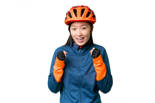Young cyclist woman over isolated chroma key background celebrating a victory in winner position
