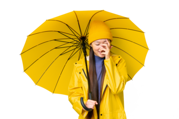 Young Asian woman with rainproof coat and umbrella over isolated chroma key background laughing