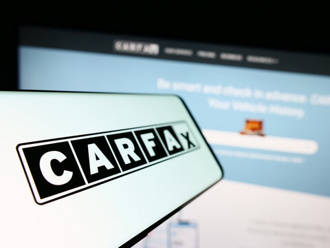Stuttgart, Germany - 07-29-2023: Smartphone with logo of American vehicle data company CARFAX Inc. on screen in front of business website. Focus on left of phone display.