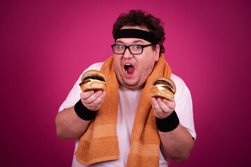 Funny fat man is engaged in fitness and and greedily eats a hamburger. Retro style. Pink background.
