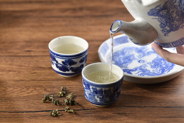 White Ceramic Chinese style Teapot pouring Chinese tea in Ceramic cup. White Ceramic Chinese style Teapot set for tea break time.