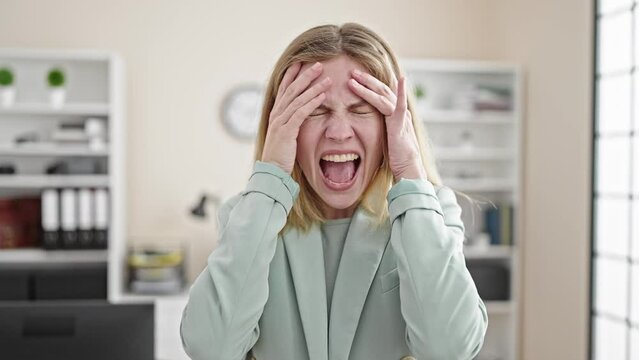Young blonde woman business worker stressed screaming at office